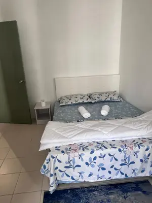 a bedroom with two beds with blue and white sheets at AYAAN COZY PRIMA HOMESTAY FREE WiFi in Tanah Rata
