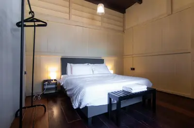 a bedroom with a bed and a table with a lamp at Aayu Heritage - Heritage Home in Stewart Lane in George Town