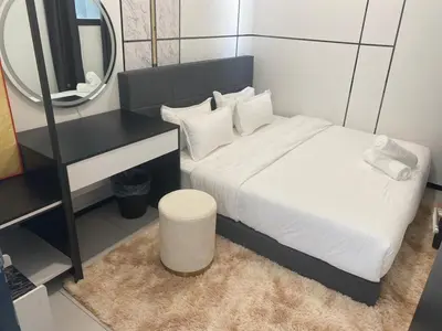 a small bedroom with a bed and a mirror at Georgetown Ins Cozy Suites 2BR in George Town