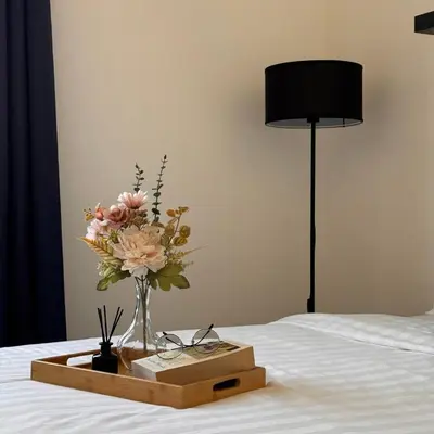 a vase of flowers on a tray on a bed at The Bay 6pax 2BR Apartment at Town Centre in Ipoh