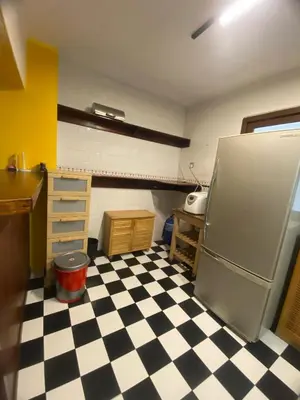 a kitchen with a black and white checkered floor at Highlanders Apartment in Tanah Rata