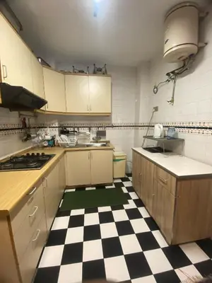 a kitchen with a black and white checkered floor at Highlanders Apartment in Tanah Rata