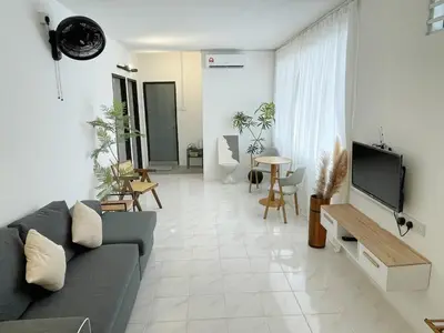 a living room with a couch and a tv at Muji Zen Minimalist Guest House in Teluk Intan