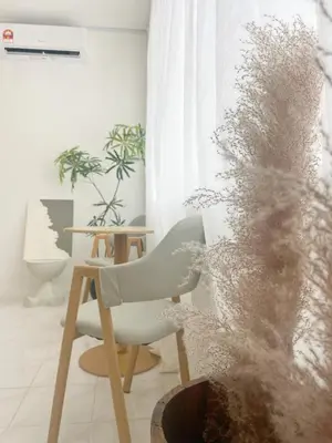 a living room with a chair and a plant at Muji Zen Minimalist Guest House in Teluk Intan