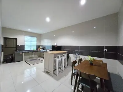 a kitchen with a table and a kitchen with a counter at HOMESTAY KLeMERU E POH in Chemor