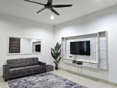 a living room with a couch and a flat screen tv at HOMESTAY KLeMERU E POH in Chemor