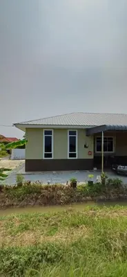 a yellow house with a car parked in front of it at Inap hujung kampung in Penaga