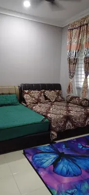 a bedroom with two beds with colorful sheets and curtains at Inap hujung kampung in Penaga