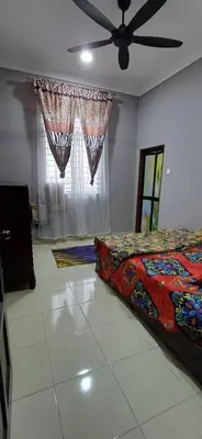 a bedroom with a bed and a ceiling fan at Inap hujung kampung in Penaga