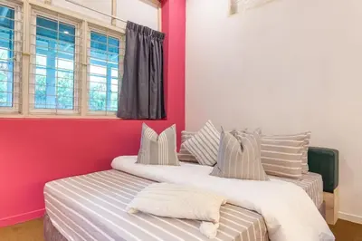 two beds in a room with red walls and windows at Unique Design House, 2BR House - Near Ipoh Local Foodies in Ipoh