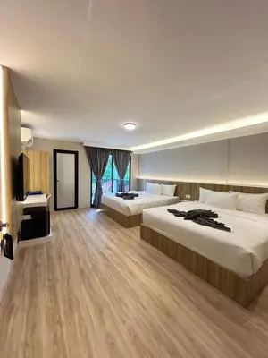 a hotel room with two beds and a television at Alva Boutique Chalet Pangkor in Pangkor