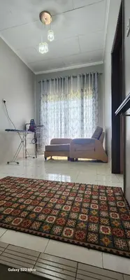 a living room with a bed and a rug at TunTeja Homestay in Sungai Petani