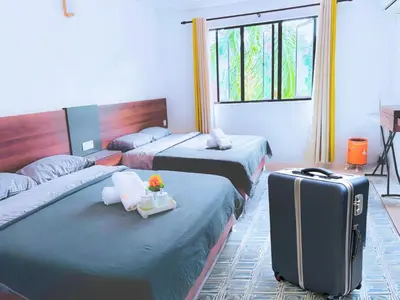 a hotel room with two beds and a suitcase at Pangkor Island Pool View Studio 2 Queen Beds 2 Min Walk to the Beach Free WiFi & Parking in Pangkor