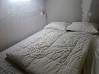 a bed with white sheets and pillows in a room at Cool view hostel in Tanah Rata