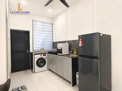 a kitchen with a refrigerator and a washing machine at The Cozy Retreat House at Bukit Mertajam in Bukit Mertajam