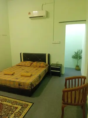 a bedroom with a bed and a chair at Tambun Lastworld Sapari Homestay in Tambun