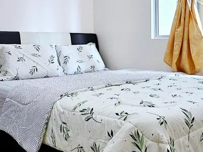 a bed with white sheets and green leaves on it at 8\u697c\u6c11\u5bbf Enjoy the Paddy Field View in Sekincan