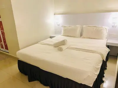 a large bed with white sheets and pillows at Sunsega Hotel in Perai
