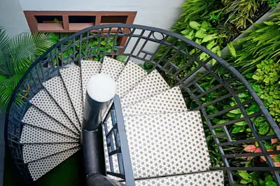 a spiral staircase in a garden with a street light at Sarang Paloh Heritage Stay in Ipoh