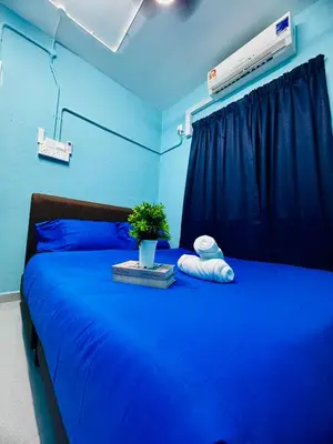 a blue bedroom with a blue bed with a plant on it at Apartment in gelugor usm in Gelugor