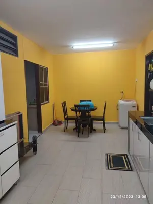 a kitchen with a table and chairs in a room at Zara's Homestay in Kuala Kurau