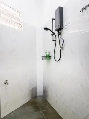 a shower in a bathroom with white tiles at Lodge 22, 5 min walk to Adventist & Pulau Tikus Market in George Town