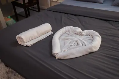 a white towel in the shape of a heart on a bed at Hutton Haven by MyStay in George Town