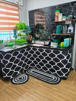 a kitchen with a black and white patterned table at Homestay Teratak D'Desa in Gua Sai