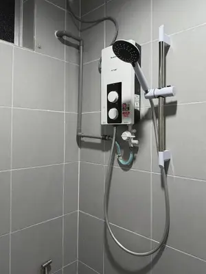 a shower with a blow dryer in a bathroom at Modern & Cozy Home Stay in Kampar