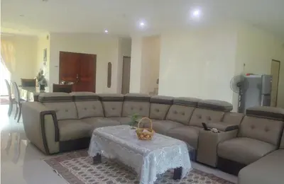 a living room with a large couch and a table at Kulim LakeView Homestay for Msliims Only in Kulim