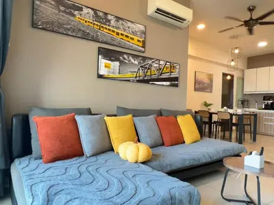 a living room with a blue couch with colorful pillows at G Home 3 - Ipoh City Centre Majestic 2R2B in Ipoh
