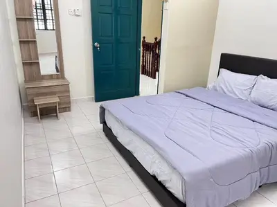 a bedroom with a bed and a green door at Menglembu Hill Home Stay in Ipoh