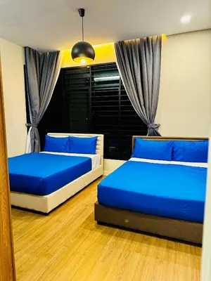 two beds in a room with blue pillows at Private Pool Villa Near Batu Ferringhi Beach in Batu Ferringhi
