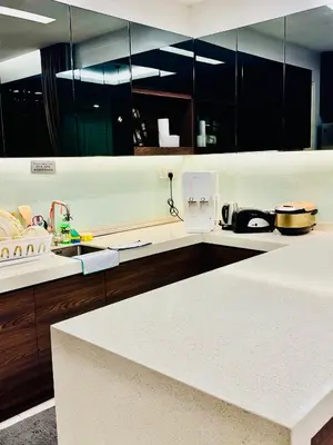 a kitchen with black cabinets and a white counter top at Private Pool Villa Near Batu Ferringhi Beach in Batu Ferringhi