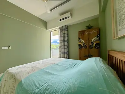a bedroom with a large bed and a window at By The Sea Batu Ferringhi, Penang Beach in Batu Ferringhi