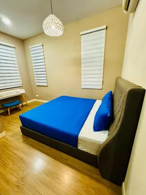 a bedroom with a bed with blue sheets and a couch at Batu Ferringhi Home Near Beach in Penang with private pool in Batu Ferringhi