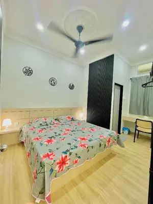 a bedroom with a bed with a floral bedspread at Homestay Deedora 87 in Seri Manjung