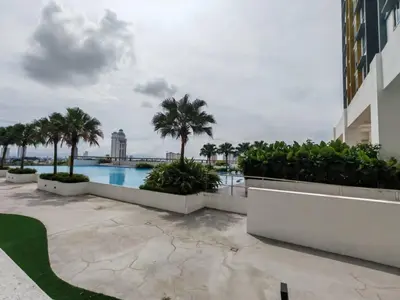 a swimming pool with palm trees and a building at Galaxy Luxury Homestay in Bukit Mertajam