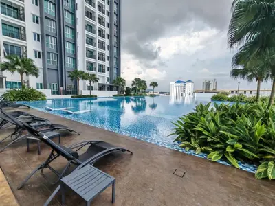 a swimming pool in a building with chairs and palm trees at Galaxy Luxury Homestay in Bukit Mertajam