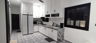 a kitchen with white cabinets and a black and white tile floor at Akasea Sojourn in Gua Sai