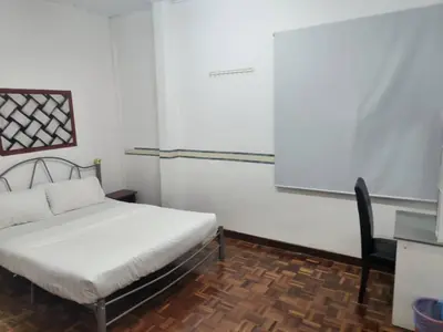a bedroom with a bed and a desk and a chair at Cool memories apartment in Tanah Rata