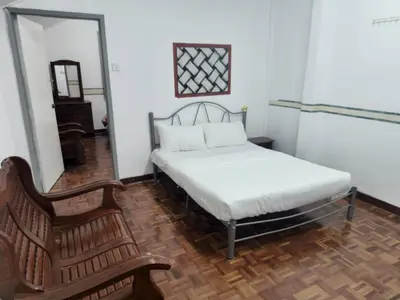 a bedroom with a bed and a chair and a mirror at Cool memories apartment in Tanah Rata