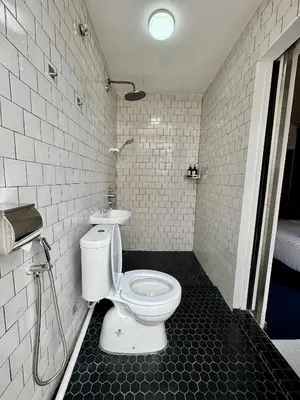 a bathroom with a white toilet in a room at The Harbour by Moonknight in George Town
