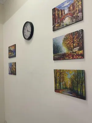 a wall with pictures and a clock on it at Teratai Bunda Homestay Tambun in Tambun