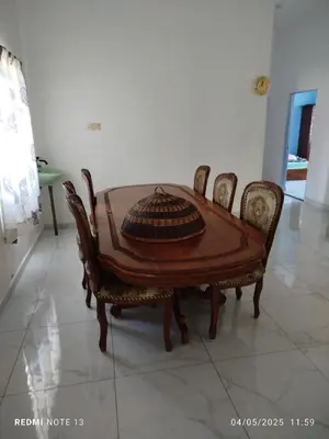 a wooden table and chairs in a room at Homestay Usrati in Taiping