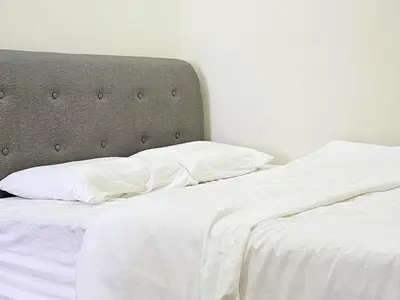 an unmade bed with white sheets and pillows at 14\u697c\u53cc\u5c42\u7a7a\u4e2d\u522b\u5885 Double Storey Penthouse Spacious Common Space for Gathering in Sekincan