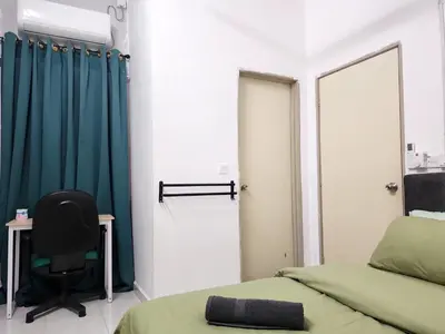 a room with two beds and a chair and a mirror at Dirgahayu Homestay II Nuri in Kulim