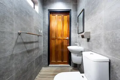 a bathroom with a toilet and a wooden door at Yenny Cottage - Canning Private House Spacious in Ipoh