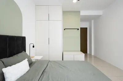 a white bedroom with a bed and a table at Arctic Breeze - Pengkalan WaterPark Pool Gym in Ipoh