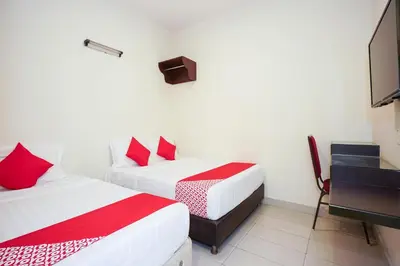 two beds with red pillows in a room at Dancenter Near Petronas Kampung Koh, Jj Hotel in Kampung Koh